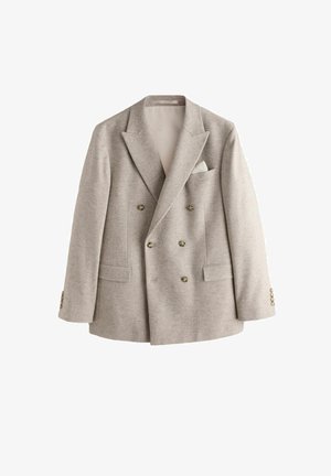 Blazer doppiopetto color beige chiaro con ampi revers, sei bottoni, due tasche frontali con pattina e un fazzoletto bianco nel taschino al petto.
