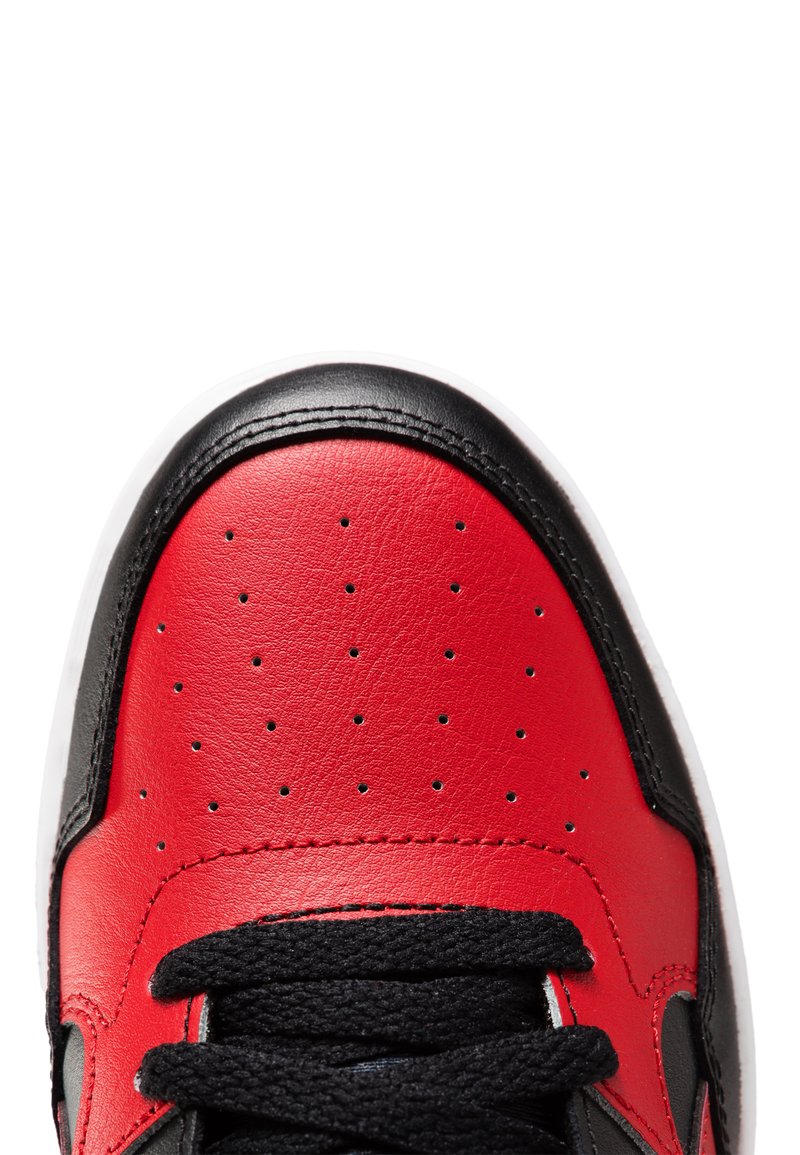 Baskets en cuir rouge avec accents noirs, bout rond, dessus perforé pour la respirabilité, et semelle en caoutchouc blanche. Lacets noirs en haut.