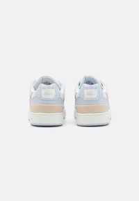 Lacoste sneakers with a white leather body, light blue suede accents, beige heel, textured surface, and embossed logo on the heel.