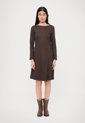 Abito marrone a maniche lunghe con scollo quadrato e forma ad A, realizzato in tessuto texture. Abbinato a stivali ankle brown.