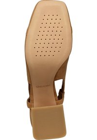 Suola di scarpa in suede marrone con tacco in gomma piatta, caratterizzata da fori di ventilazione e una superficie testurizzata per la presa. Marchio Geox visibile.