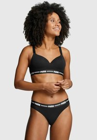 Schwarzer Sport-BH und passender String-Tanga mit konturiertem Design, breitem elastischen Bund mit weißem "PUMA"-Logo und verstellbaren Trägern.