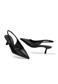 Tacones kitten negros con punta afilada y tira trasera, con correas delgadas y un tacón triangular bajo, sobre un fondo blanco.