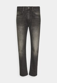 Vaqueros de mezclilla negra con un diseño de pierna recta, que presentan un ligero desgaste y un estilo clásico de cinco bolsillos. Cierre de botón metálico en la cintura.