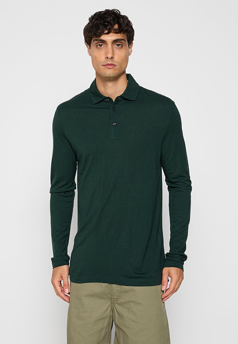 Dunkelgrünes Longsleeve-Polohemd, aus weichem Stoff mit einem spitzen Kragen und einer Dreiknopf-Leiste. Schlichtes Design, ohne Muster oder Akzente.