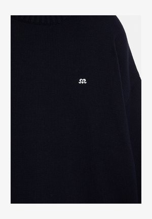Dark navy blue knitted sweater with small white embroidered logo on the chest, featuring a round ribbed neckline.