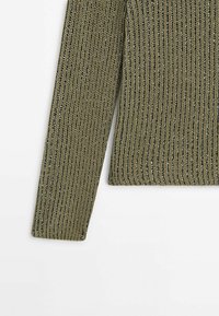 Pull en maille côtelée vert olive avec une surface texturée. Il présente une coupe ajustée et des manches longues avec des fils métalliques subtils.