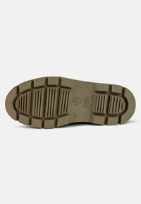 Suela de zapato de goma marrón con profundos surcos y estrías para mejor tracción. Presenta un logo circular y marcas de tamaño. Tacón plano, punta redondeada.