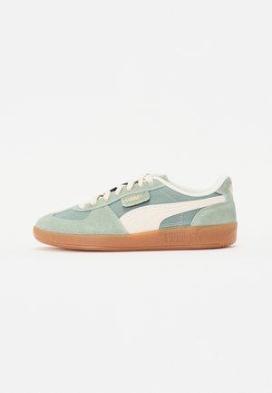 Hellgrüner und weißer Puma-Sneaker mit Gummisohle, Wildleder- und Mesh-Obermaterial, weißen Schnürsenkeln und dem charakteristischen Puma-Streifen an der Seite.