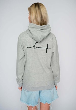 Hoodie gris clair avec une poche kangourou à l'avant et un graphique de battement de cœur noir avec le mot "love" au dos. Tissu doux, manches longues et capuche.