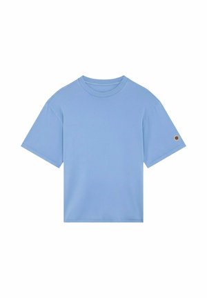 T-shirt bleu clair à manches courtes avec col rond et petit patch circulaire sur la manche gauche, présenté sur fond blanc.