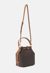 Brązowa torebka typu bucket z wzorem, z jasnobrązowymi skórzanymi dodatkami, regulowanym paskiem i złotymi okuciami. Posiada zapięcie na sznurek i płaskie dno zapewniające stabilność.