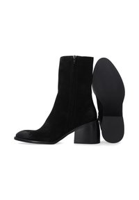 Schwarze Wildleder-Stiefeletten mit seitlichem Reißverschluss, runder Zehenform und einem klobigen Absatz. Glatte Textur mit matter Oberfläche und ohne sichtbare Muster.