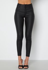 Leggings noirs taille haute en similicuir avec une texture lisse, dotés d'une fermeture à boutons sur le devant, de poches latérales et d'une coupe cintrée.