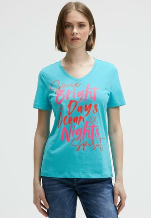Turquoise short-sleeve T-shirt with a V-neck; features vibrant pink text saying "Bright Days Ocean Nights Spirit." Soft cotton material.