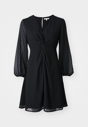 Abito nero con scollo a V, fronte attorcigliato e maniche a palloncino trasparenti. Tessuto testurizzato con piccolo motivo a pois. Orlo a metà ginocchio.