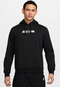 Felpa nera con cappuccio realizzata in tessuto morbido, dotata di tasca frontale, cordino regolabile e un logo grafico "JUST DO IT" sul petto.