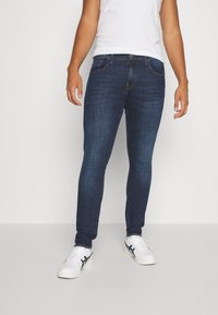 Mörkblå slim-fit jeans i denim, med en klassisk femfickdesign, lätt blekning och en standard knapplåsning med dragkedja.