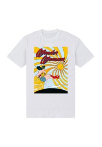 Witte katoenen t-shirt met een graphic print van Wonder Woman in rode laarzen, een lasso en blauwe sterrenmotief shorts tegen een gele zonnestraal achtergrond.