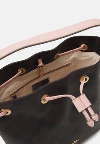 Hnědá texturovaná kožená kabelka typu bucket s růžovými akcenty, vybavená prostorným vnitřkem, stahovacím uzávěrem a zlatými kovovými detaily.