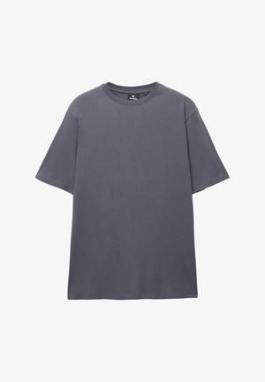 Szürke pamut póló kerek nyakkivágással, rövid ujjal és laza szabással. Simaság jellemzi, nincsenek minták vagy látható fémalkatrészek.