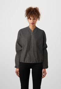 Casaco bomber cinza feito de tecido texturizado, com fecho por zipper, colarinho canelado e punhos elásticos, com um corte descontraído e bolsos laterais.