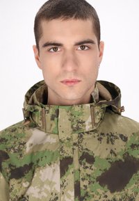 Camo-jack met hoge kraag, voorzien van een mix van groene, bruine en tan patronen, gestructureerde stof en verstelbare hardware-accenten.