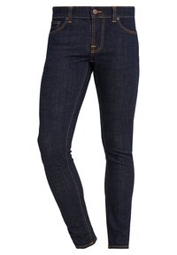 Mörkblå denimjeans med en slim fit, med orange sömmar, femfickorsdesign och en enkelskans vid midjan.