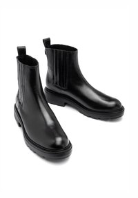 Czarne skórzane botki za kostkę z elastycznymi panelami bocznymi, gładką fakturą, okrągłym noskiem oraz solidną gumową podeszwą z niskim obcasem.