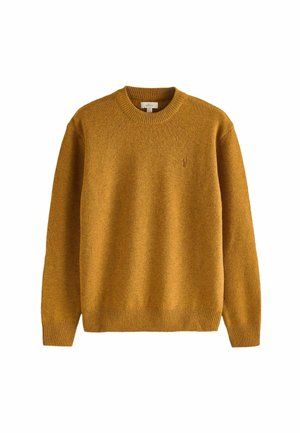 Maglione giallo senape a maglia con scollo rotondo, polsini e orlo a coste. Presenta un piccolo logo ricamato sul petto. Texture morbida.