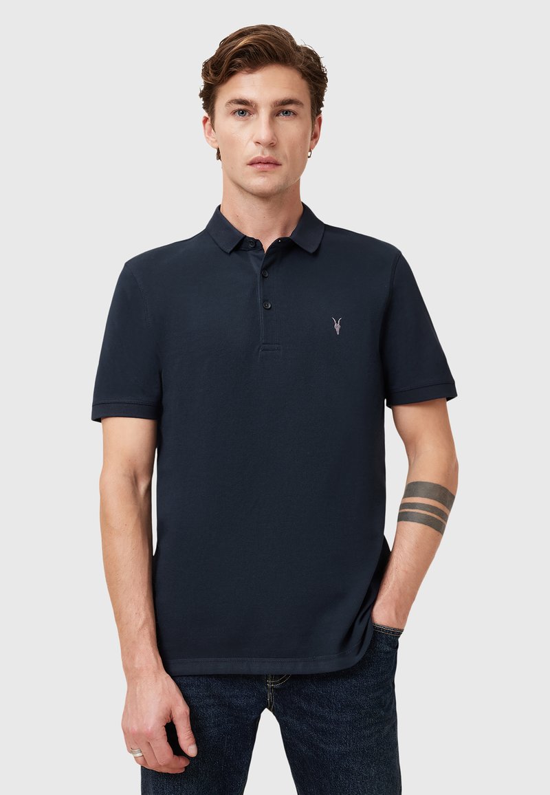 Navyblaue Poloshirt aus Baumwolle mit Kragen, kurzen Ärmeln, einer Dreiknopf-Leiste und einem kleinen gestickten Logo auf der Brust.