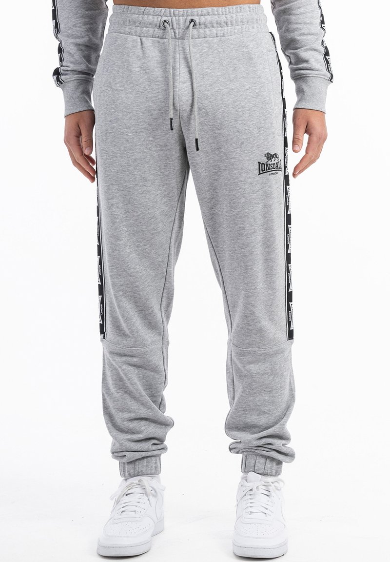 Graue Sweatpants aus weichem Stoff, mit elastischen Bündchen, einem verstellbaren Bund und schwarzen Seitenstreifen mit Branding-Details.