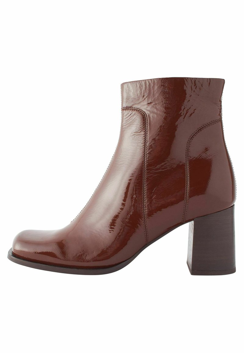 Bottine en cuir verni bordeaux avec un bout arrondi, des lignes épurées et un talon épais. Texture lisse sans quincaillerie visible.