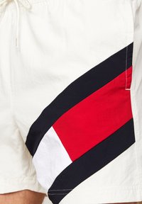 Pantaloni da bagno da uomo in tessuto leggero, con un grande design geometrico rosso, bianco e blu navy sul lato e una vita elastica.