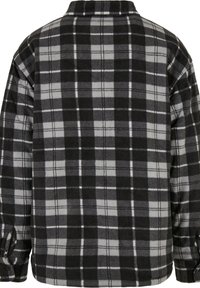 Chemise en flanelle noire et grise à motifs à carreaux, avec un col, des manches longues et des boutons aux poignets.