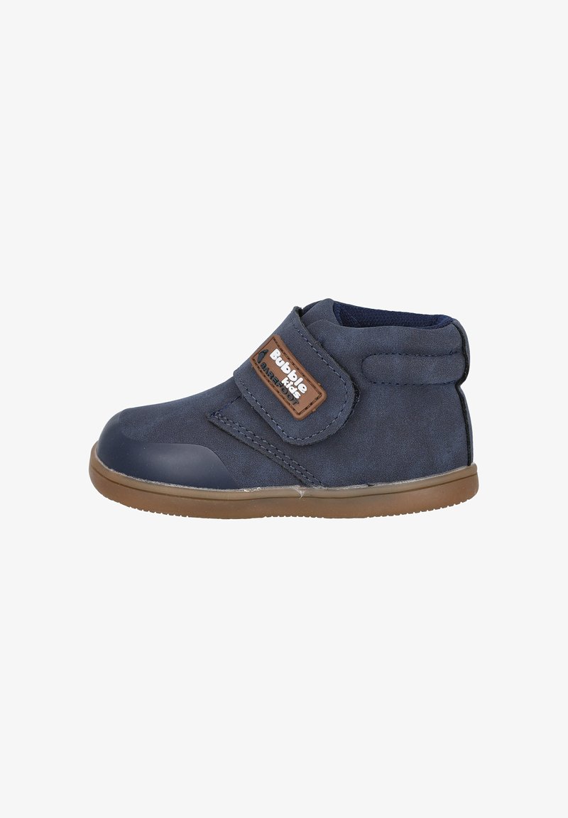 Botín azul marino con textura de ante, suela de goma y correa ajustable de Velcro. Presenta una etiqueta marrón con el logo "Bubble Kids".