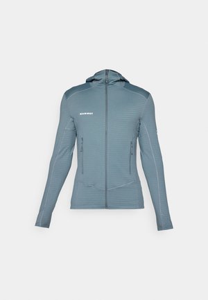 Lichtblauwe softshell jas met capuchon en ribbelstructuur, voorzien van voorzakken met rits en contrasterende stiknaaddetails voor een extra accent.