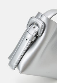 Borsa a mano in pelle argento con un design strutturato, caratterizzata da una tracolla larga e una fibbia decorativa. Texture liscia con sottili dettagli di cucitura.