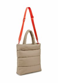 Beige padded tote bag with an orange adjustable strap and dual top handles. Soft texture with stitched horizontal lines for detail.