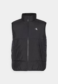 Schwarze isolierte Weste mit hohem Kragen, Frontreißverschluss und gesteppter Struktur. Verfügt über ein Logo auf der oberen linken Seite. Glatte, leichte Textur.