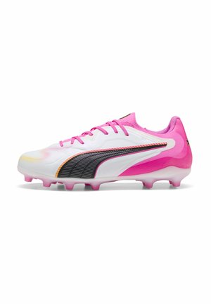 Chaussure de football blanche et rose avec logo Puma noir, lacets roses et crampons moulés sur fond blanc, vue de côté.