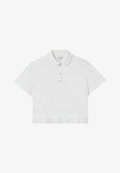 Polo shirt bianco a maniche corte con colletto, pattina con cinque bottoni dorati, taschino sul petto e dettaglio sul fondo plissettato.