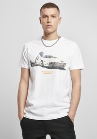 Bijela pamučna majica s grafičkim dizajnom automobila s likom, natpisom "Kada te vikend snažno udari" i kratkim rukavima.