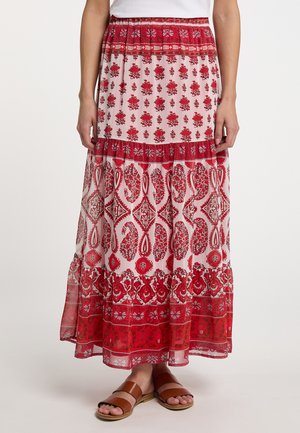 Maxi nederdel i gennemsigtigt stof med et blomsterprint i rød og pink, med lagdelte flæser og en behagelig elastisk talje. Brune slidesandaler nedenfor.