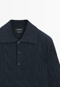 Pull en maille bleu marine foncé avec col côtelé, motif torsadé et quatre boutons noirs le long de la patte de boutonnage avant. Tissu doux et texturé.