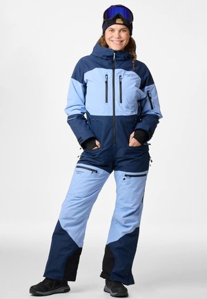 Blauwe en lichtblauwe skibroek met meerdere ritssluitingen, een capuchon en een aansluitend ontwerp. Heeft zwarte accenten en een gladde textuur.
