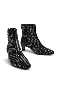 Czarne botki na kostkę z szpiczastym noskiem, o błyszczącym wykończeniu, ozdobione srebrnymi ćwiekami na cholewce i z niskim obcasem.