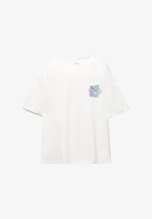 Bela kratka majica s kratkimi rokavi iz bombaža, ki ima barvit cvetlični vzorec na levi strani prsnega dela v odtenkih vijolične in zelene.