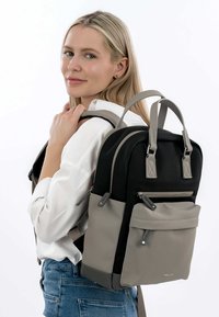 Mochila negra y gris con dos asas superiores y correas ajustables. Tela suave, bolsillo frontal con cremallera y costuras detalladas.