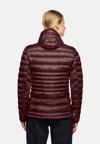 Giacca a vento bordeaux con cappuccio, caratterizzata da un design trapuntato, una texture liscia e polsini elasticizzati, che mette in mostra una silhouette aderente.
